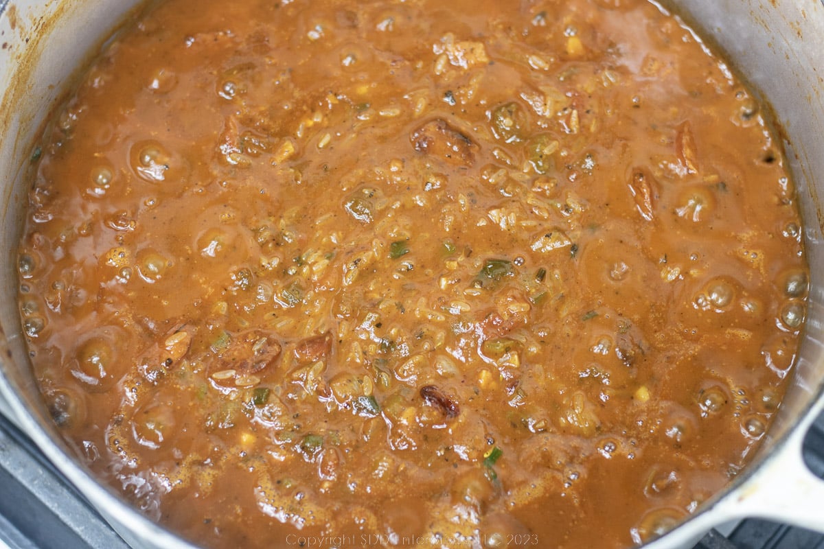 jambalaya base with rice simmering in a Dutch oven