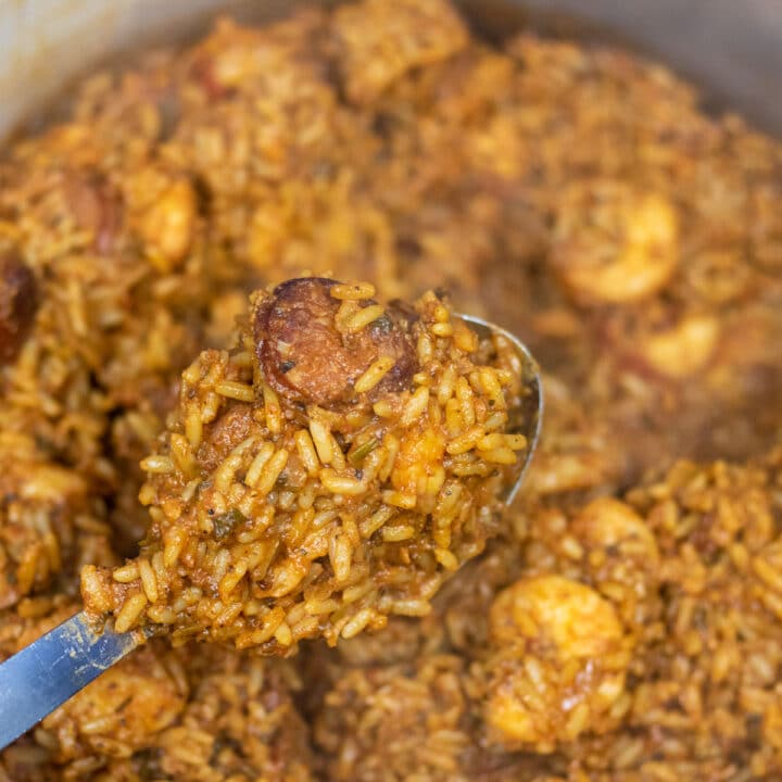 Creole Jambalaya on a serving spoon over a Dutch oven