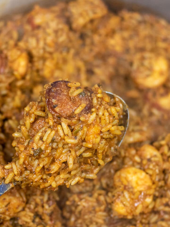 Creole Jambalaya on a serving spoon over a Dutch oven