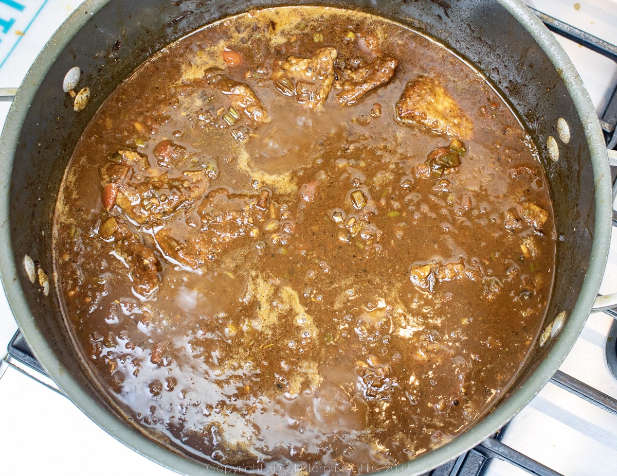 simmering grillades in brown gravy in a dutch oven