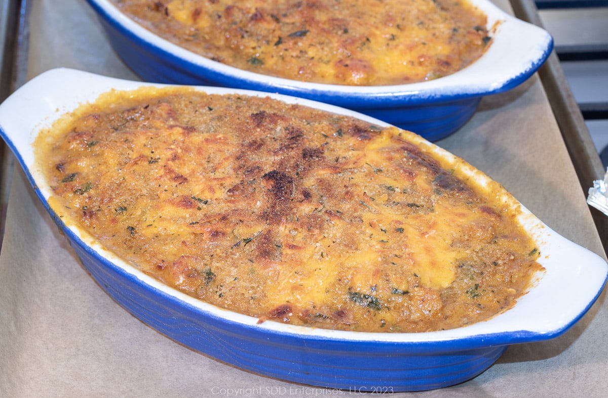 two baked crawfish au gratins on a baking sheet