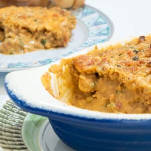 crawfish au gratin in a gratin dish with a serving plate in the background