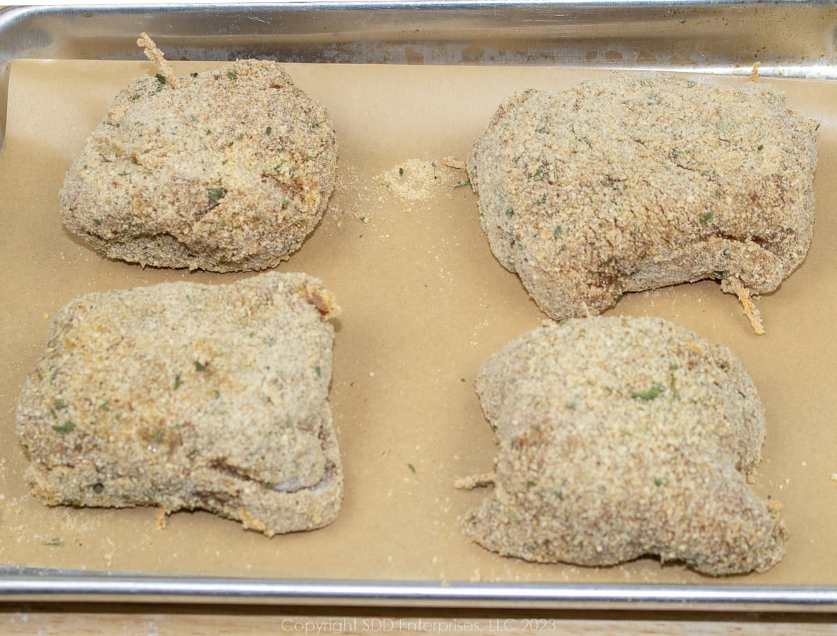 breaded chicken kievs on a baking sheet 