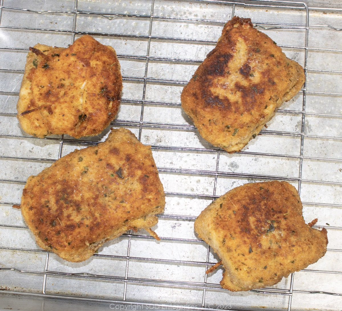 fried chicken kievs on a baking rack ready for the oven