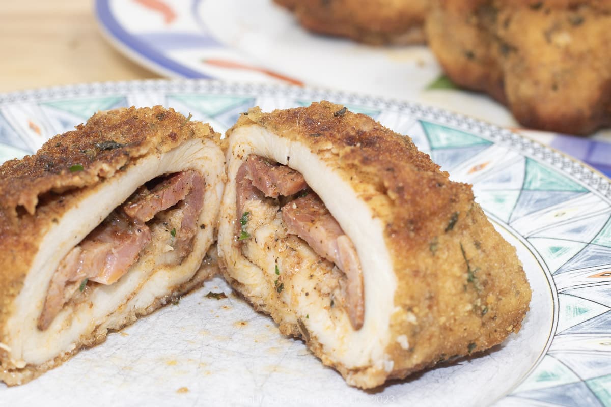 chickens kiev sliced in two on a green and white plate