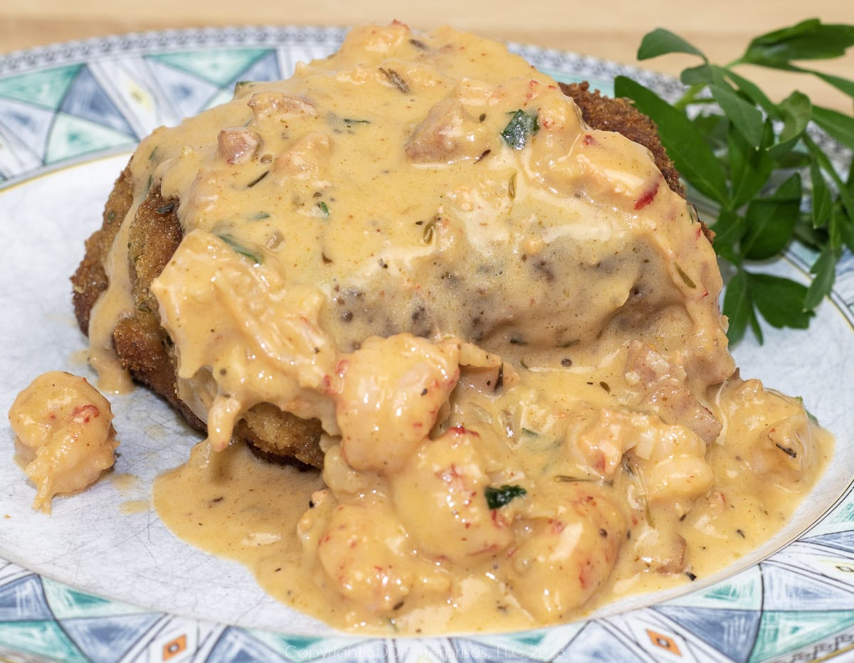 chicken kiev with crawfish butter sauce on a green and white plate