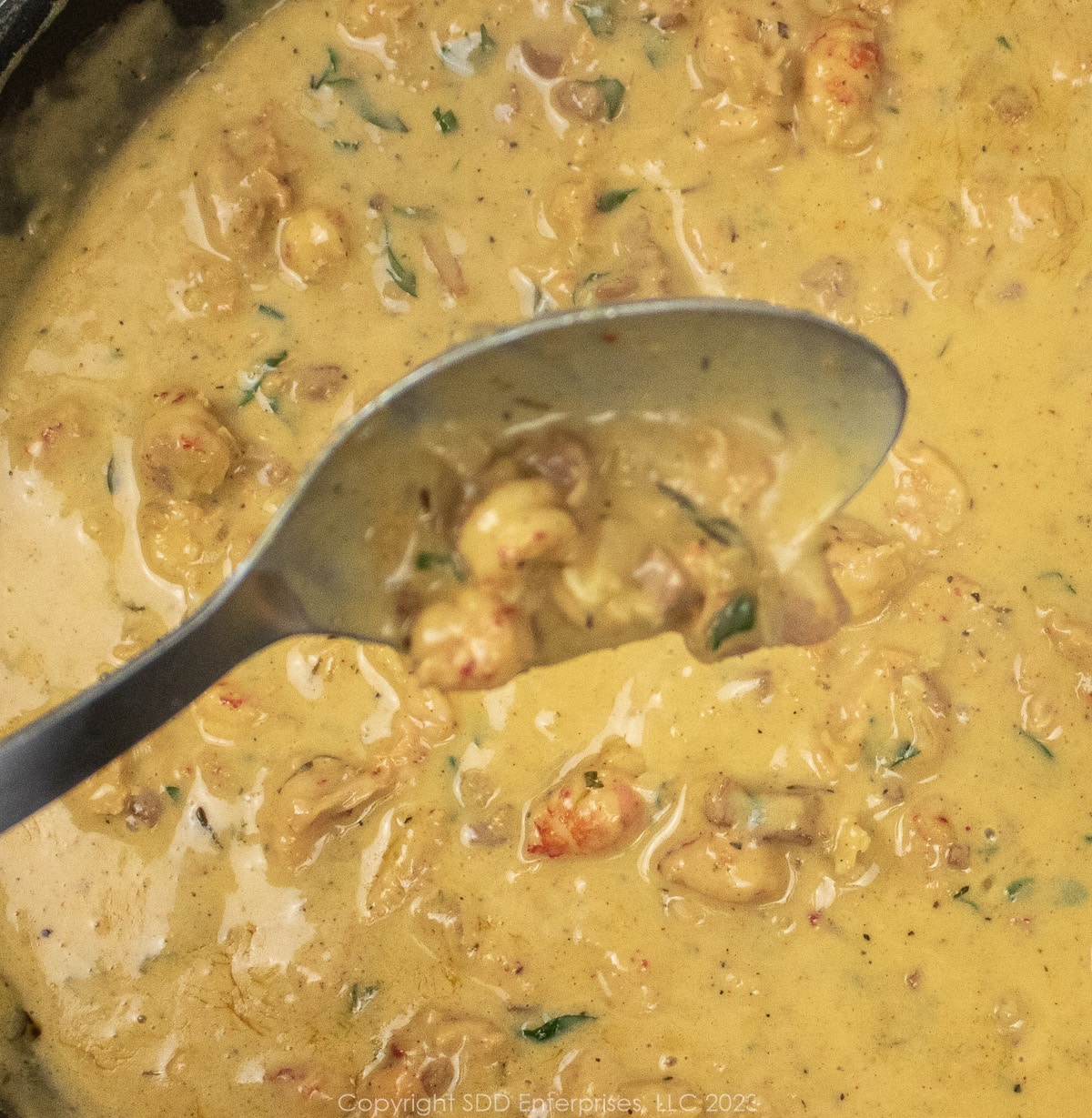 crawfish butter sauce in a serving spoon