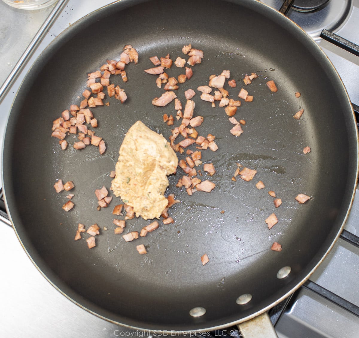 crawfish compound butter added to a saute pan with andouille