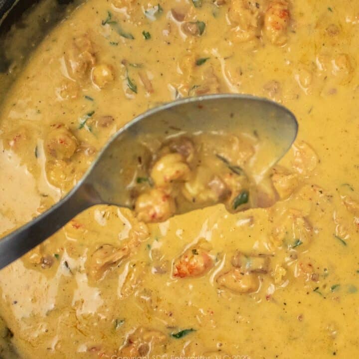 crawfish butter sauce on a serving spoon over a skillet