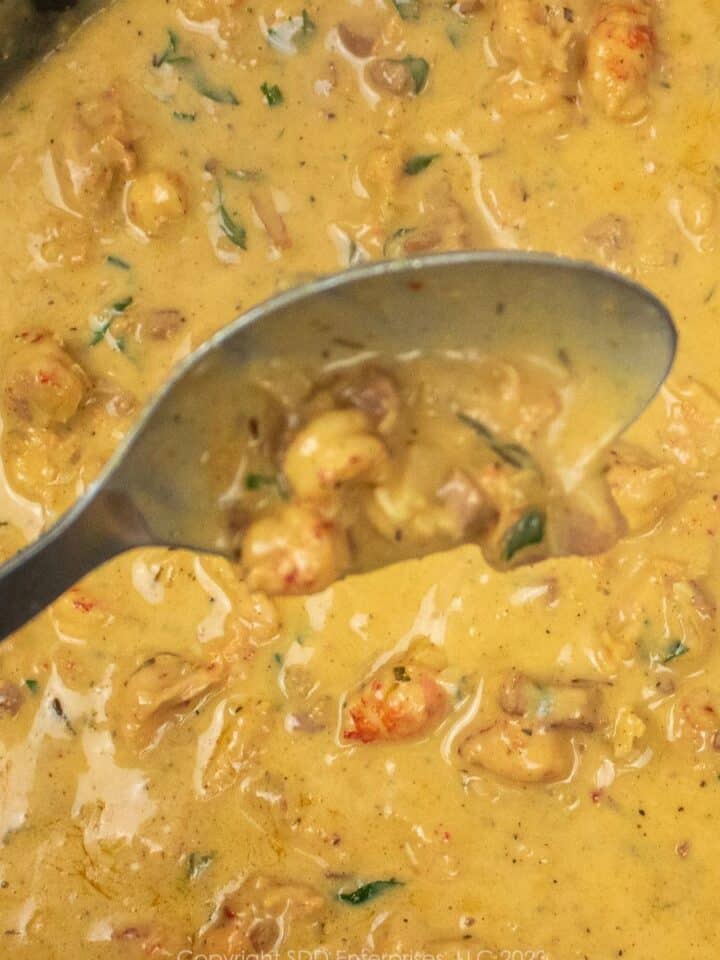 crawfish butter sauce on a serving spoon over a skillet