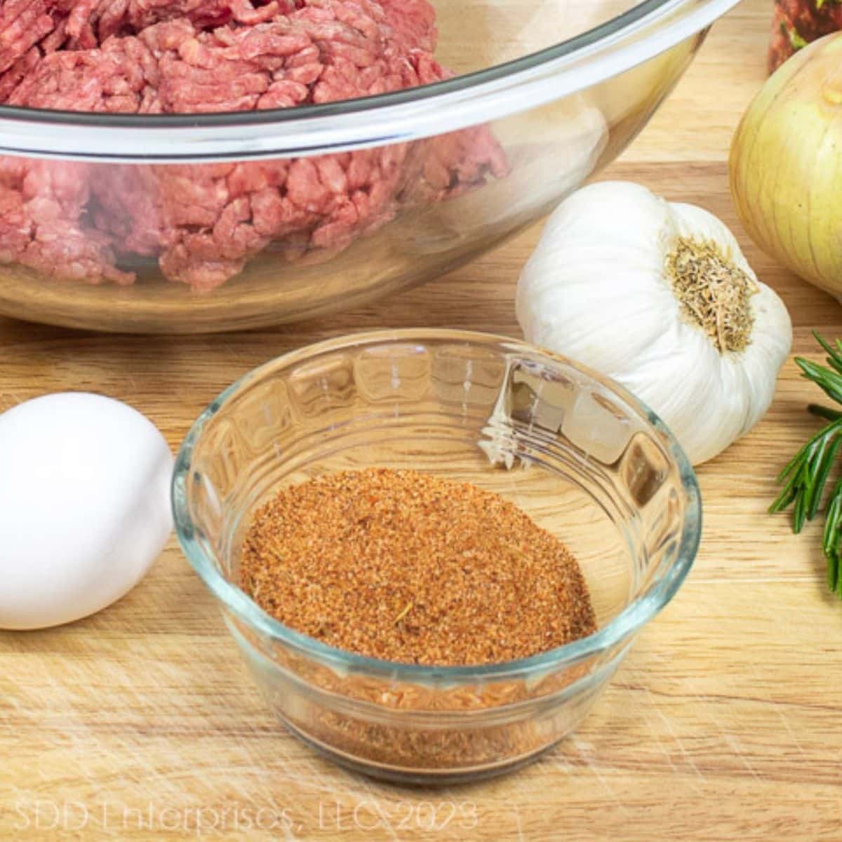 cajun seasonings in a bowl with other ingredients on a cutting board