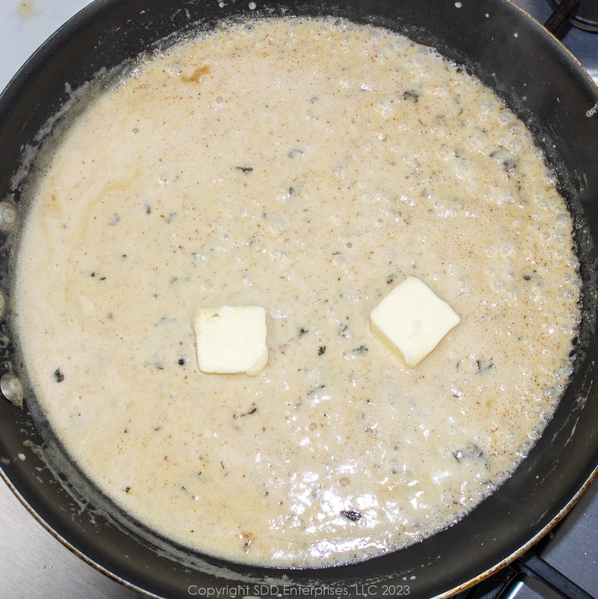 Butter added to simmering sauce in a saute pan