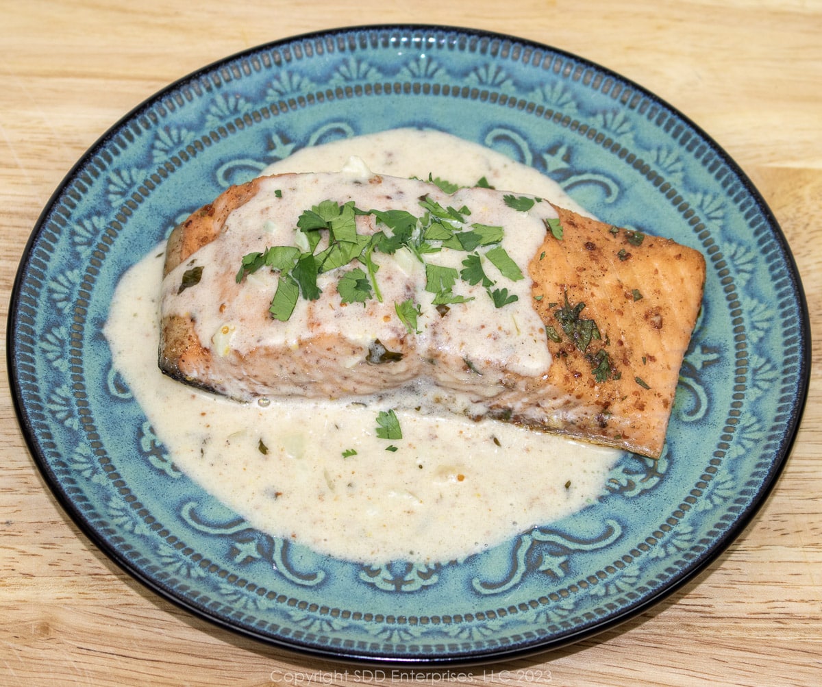 Baked Salmon on a blue green plate with Cream Sauce