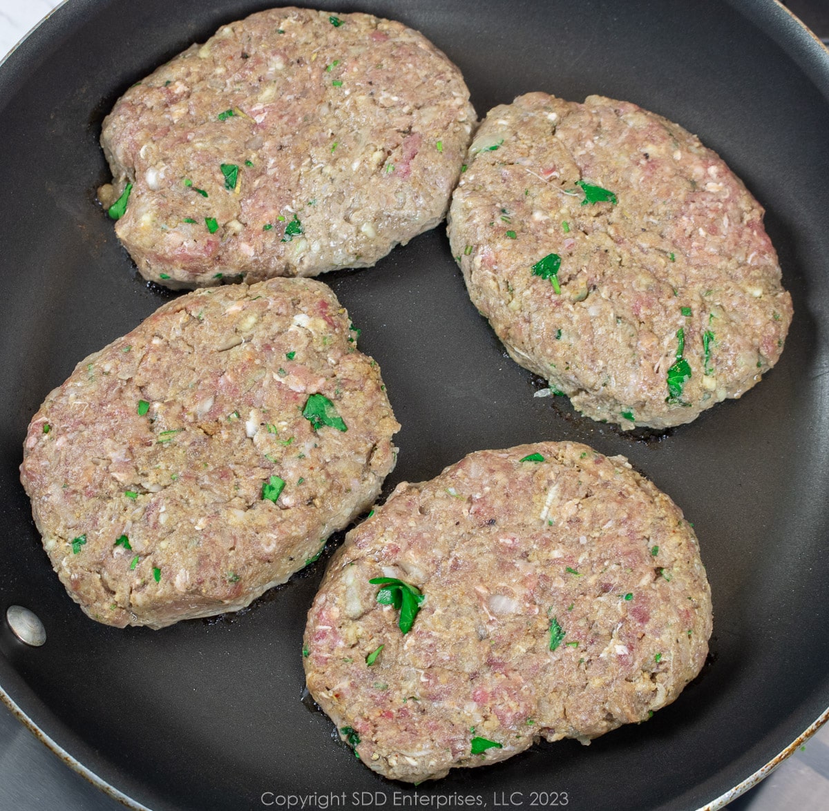 four oval shaped steak patties