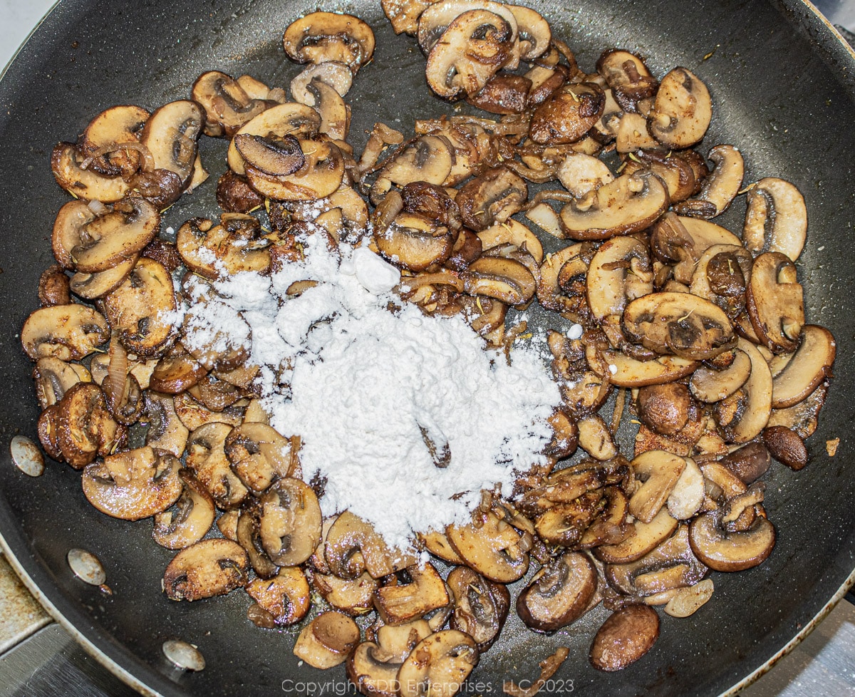 AP flour added to seasoned mushrooms in a frying pan