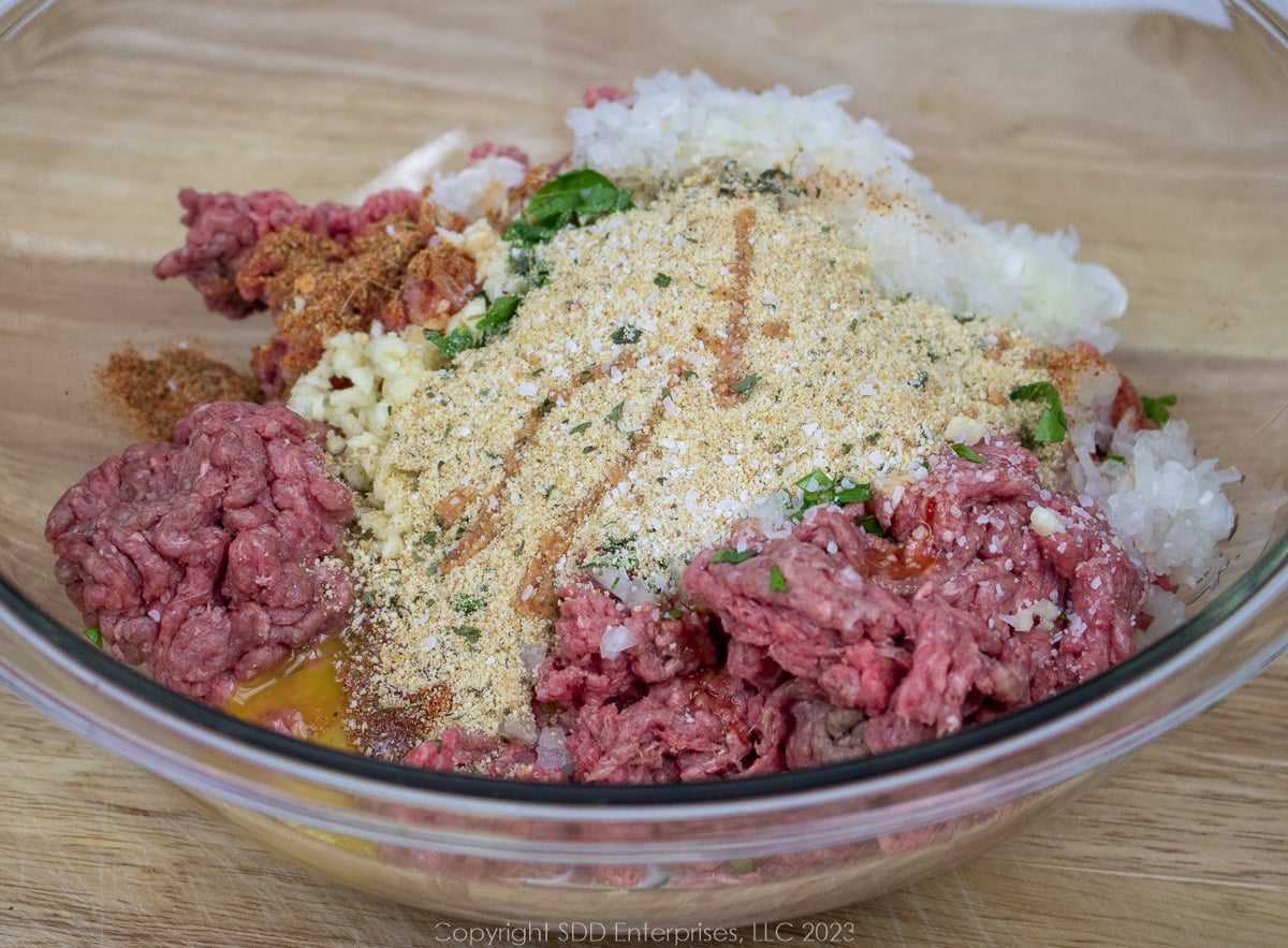 Salisbury steak ingredients in a glass bowl before mixing