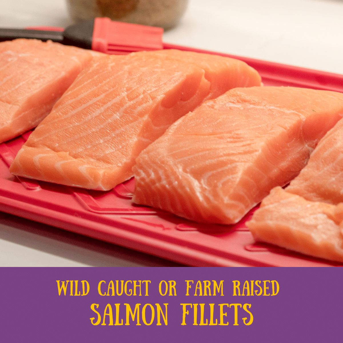 uncooked salmon fillets on a red platter