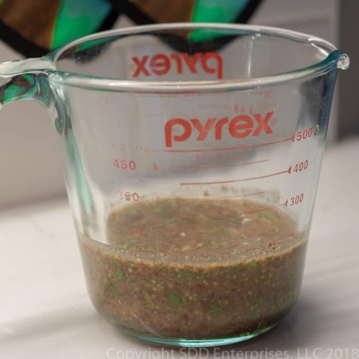 cilantro creole mustard marinade in a measuring cup