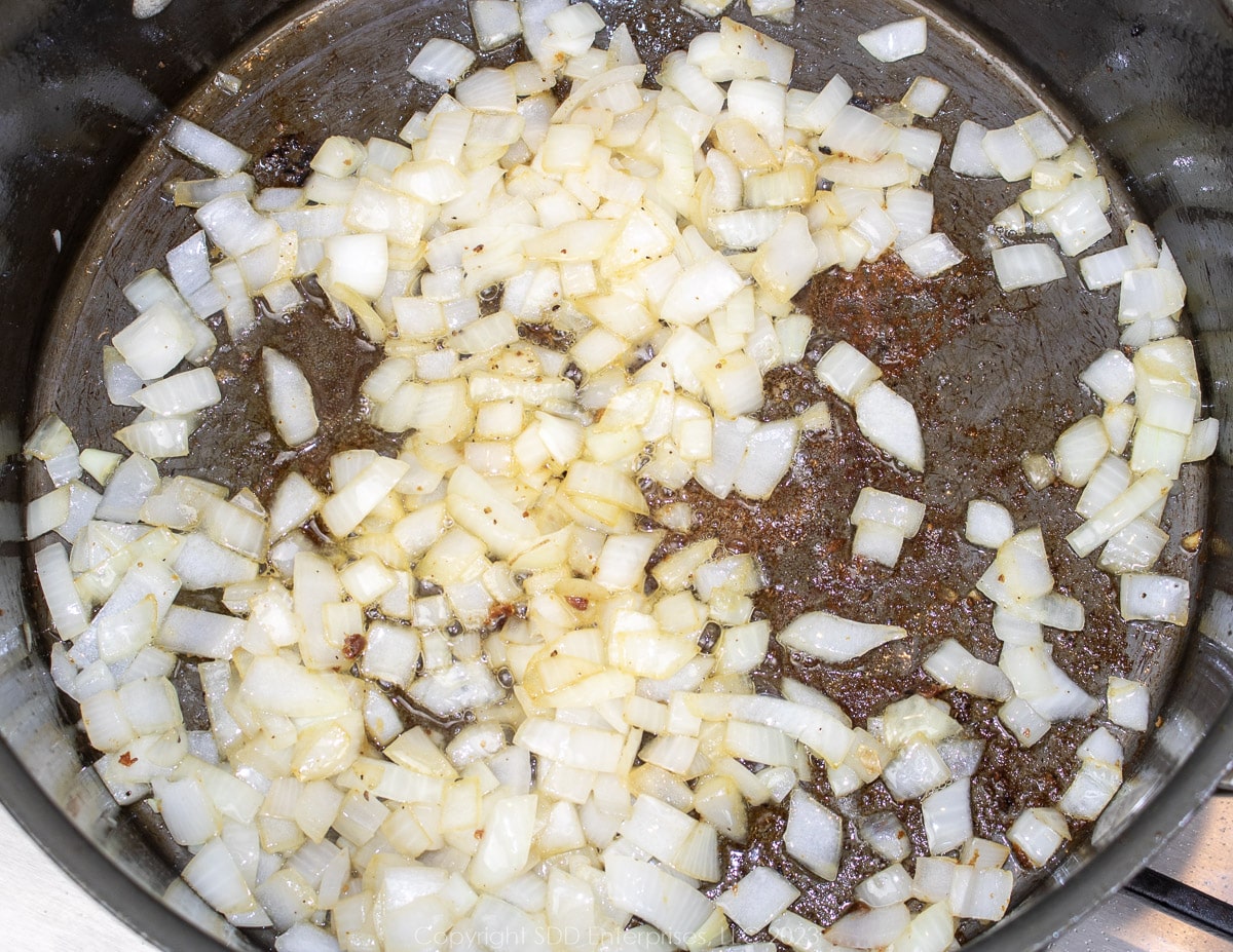 chopped onions frying in fat in a Dutch oven