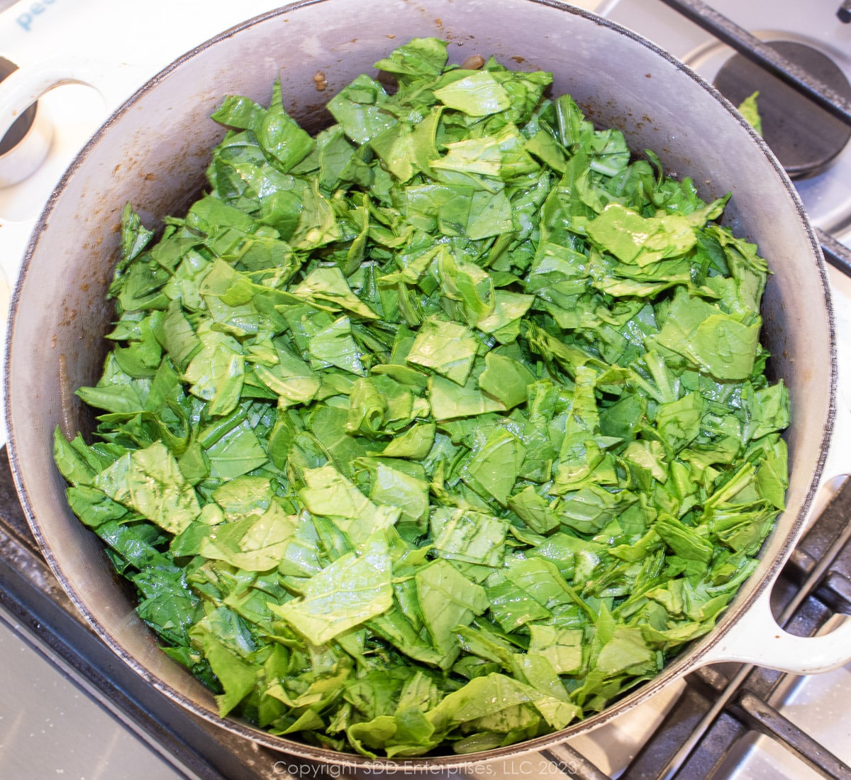 chopped turnip greens added to a Dutch oven