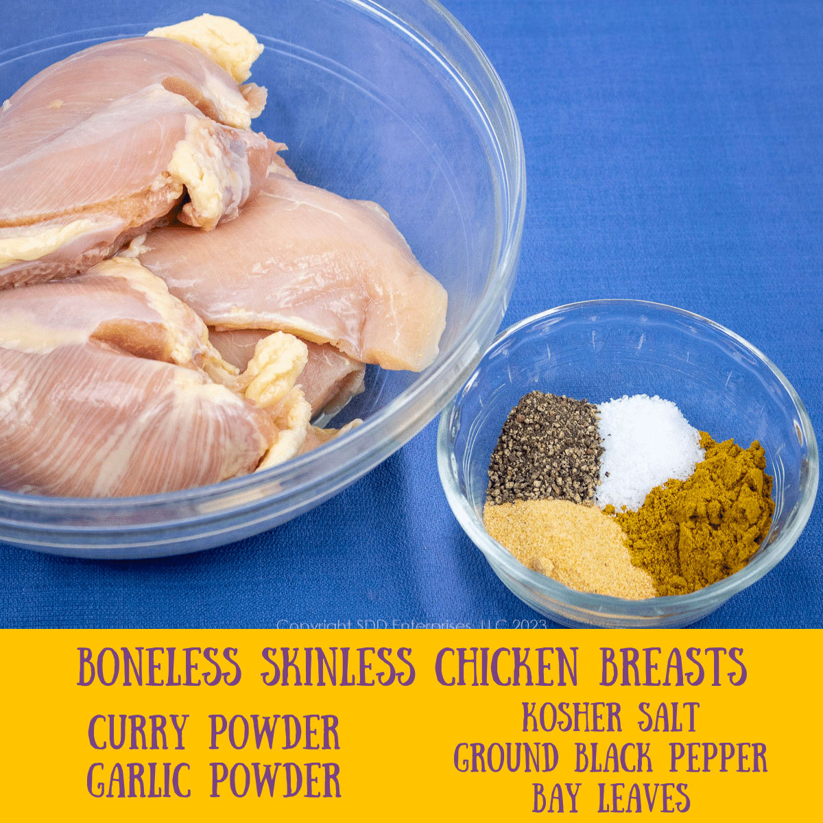 fresh chicken breasts in a bowl and a bowl of spices