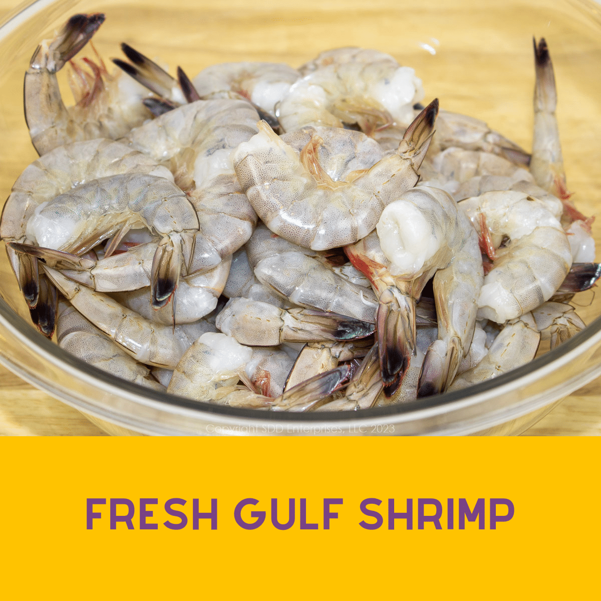 a glass bowl with fresh unpeeled shrimp