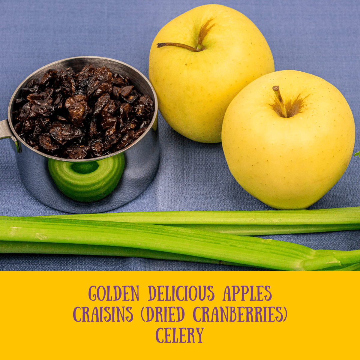 a cup of dried cranberries, two apples and celery stalks