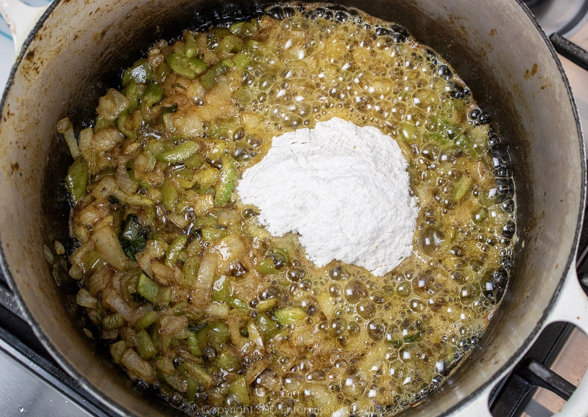 AP flour added to sautéing vegetables in a Dutch oven