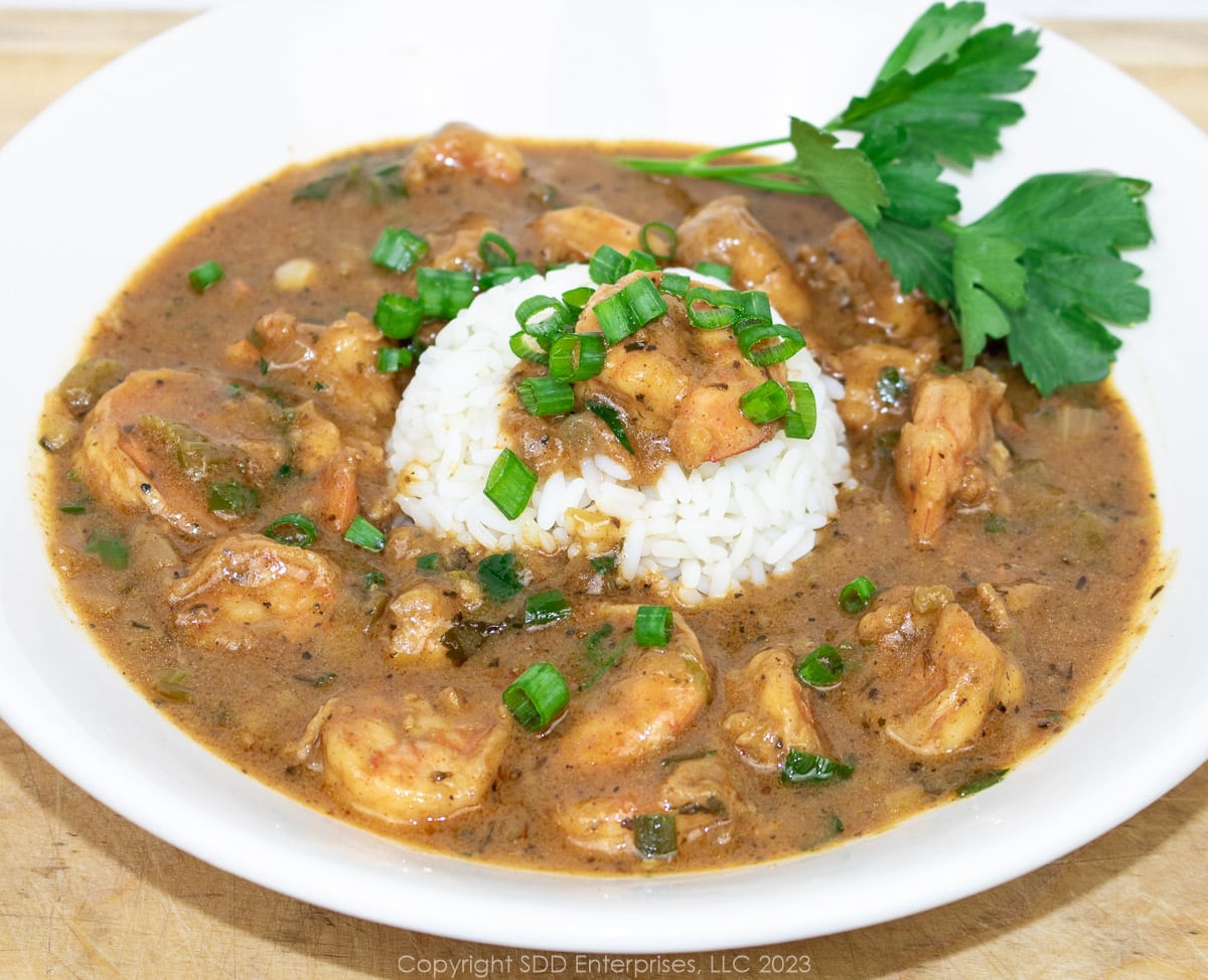 shrimp étouffée with rice and garnish n a white bowl