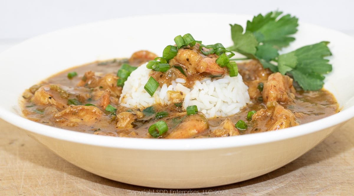 shrimp étouffée with rice and garnish n a white bowl