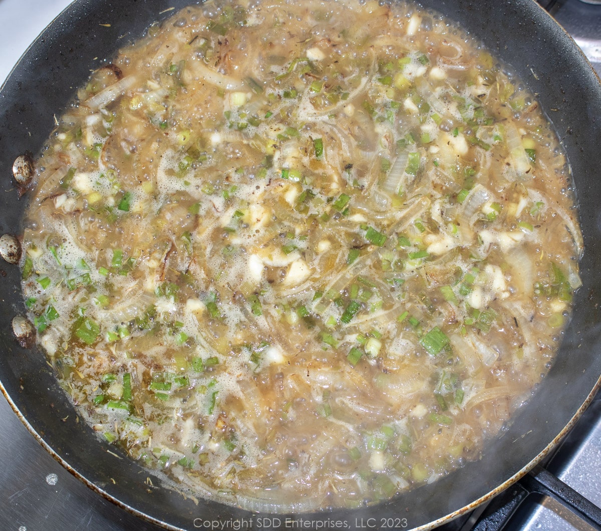 simmering wine sauce in a saute pan