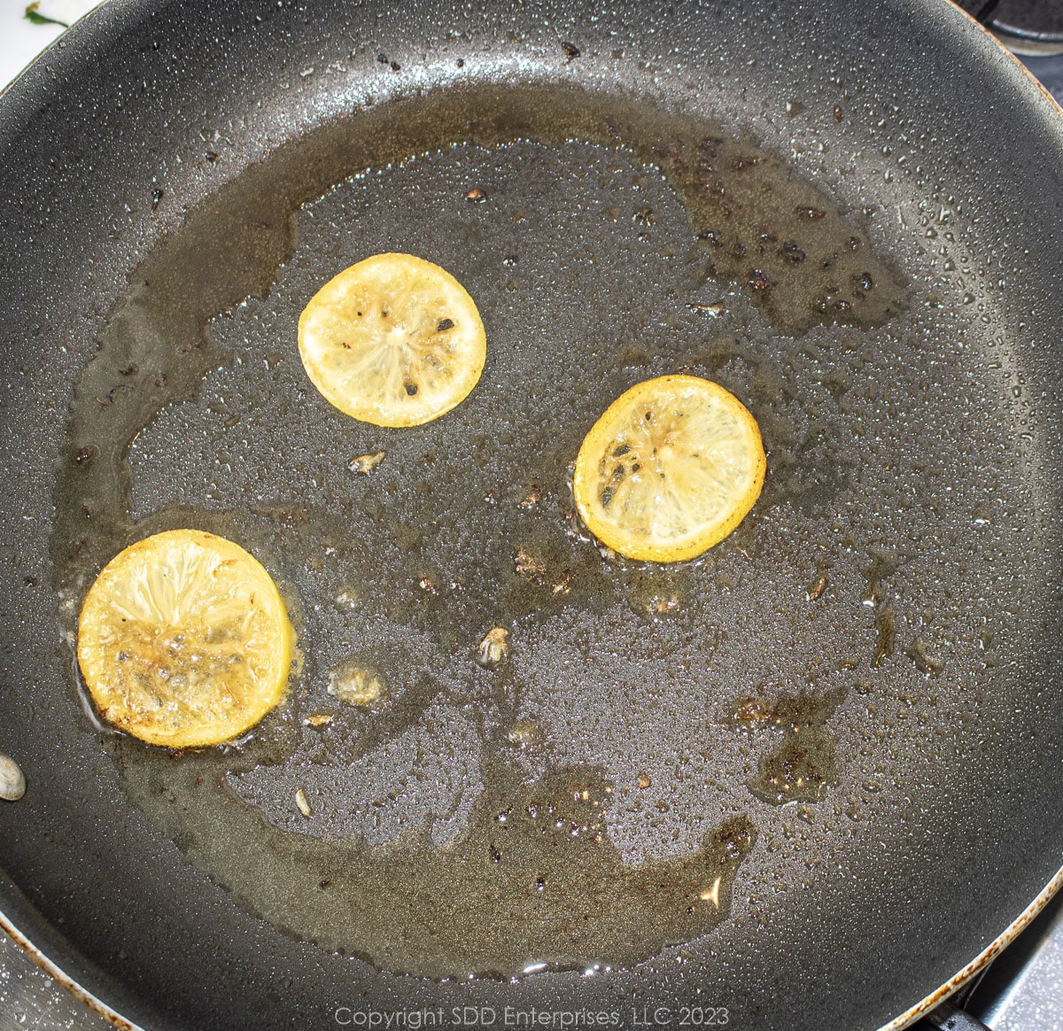 lemon slices searing in a fry pan