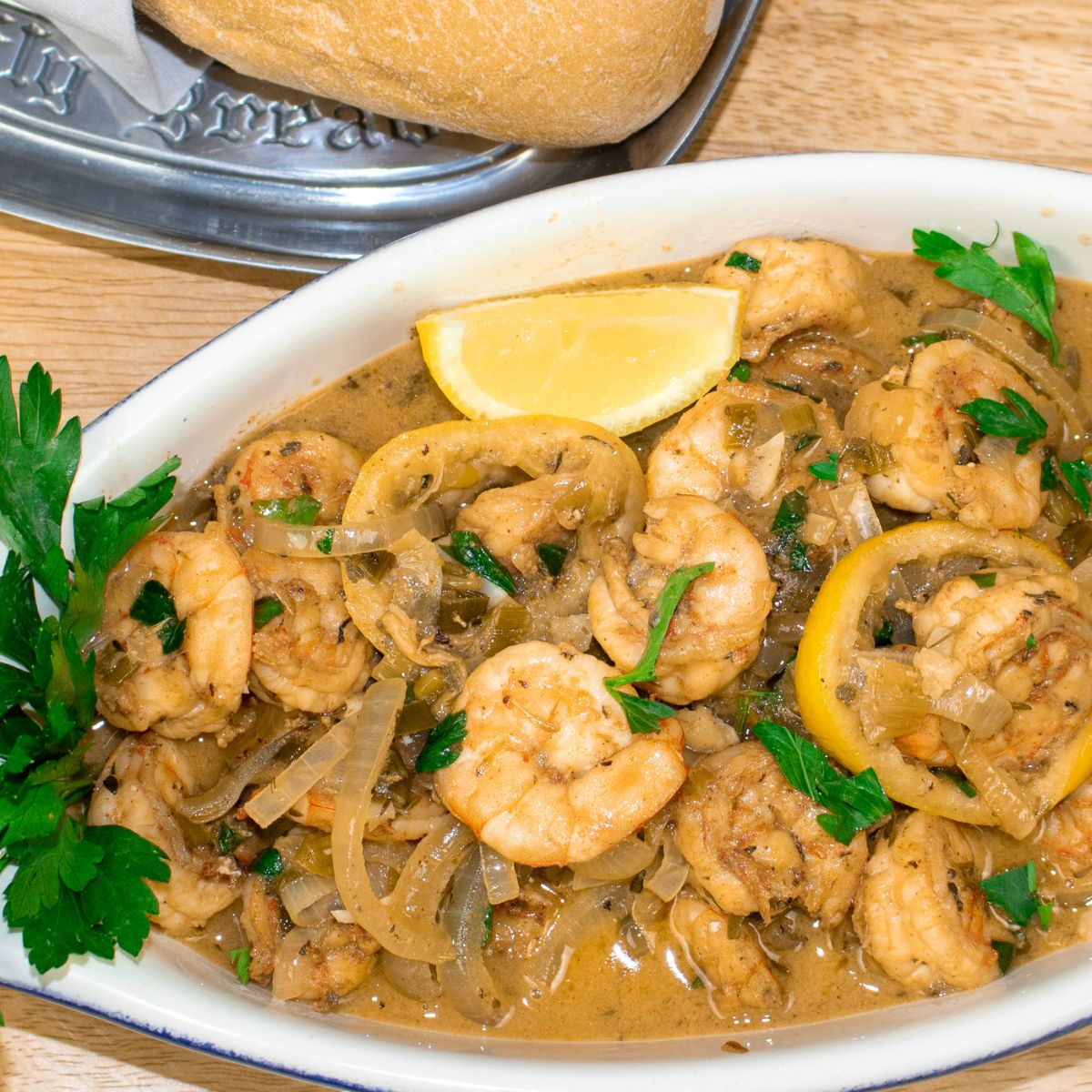 Shrimp in White Wine Sauce in a serving dish with garnish