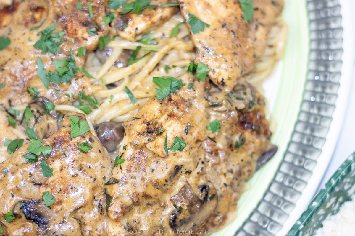 Chicken with Creamy Mushroom Sauce over pasta on a serving platter.
