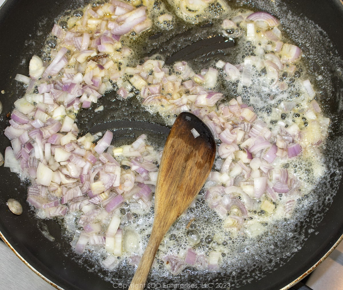 chopped shallots sautéing in butter in a skillet