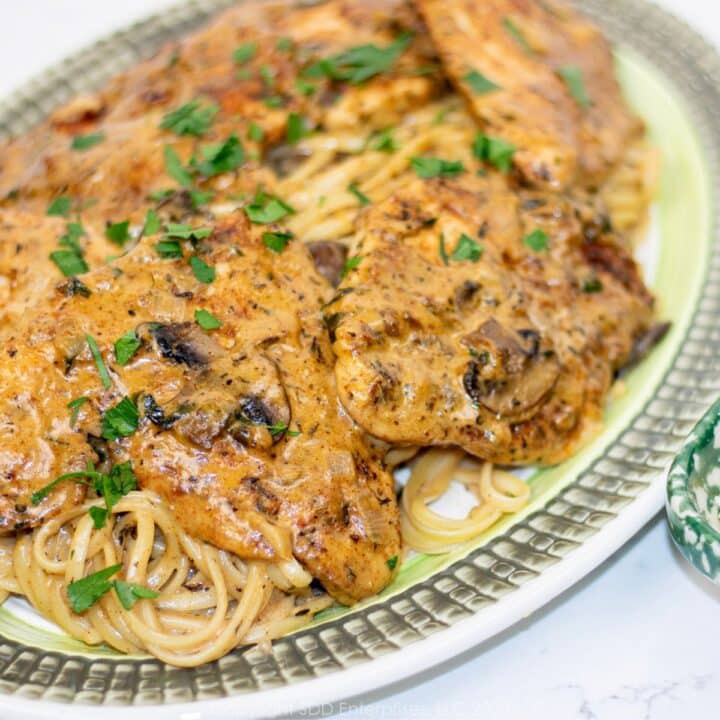 Chicken with Creamy Mushroom Sauce over pasta on a serving platter