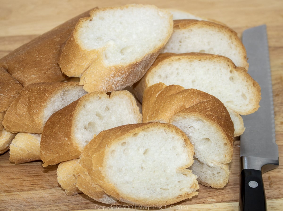 slices of French bread with a knife