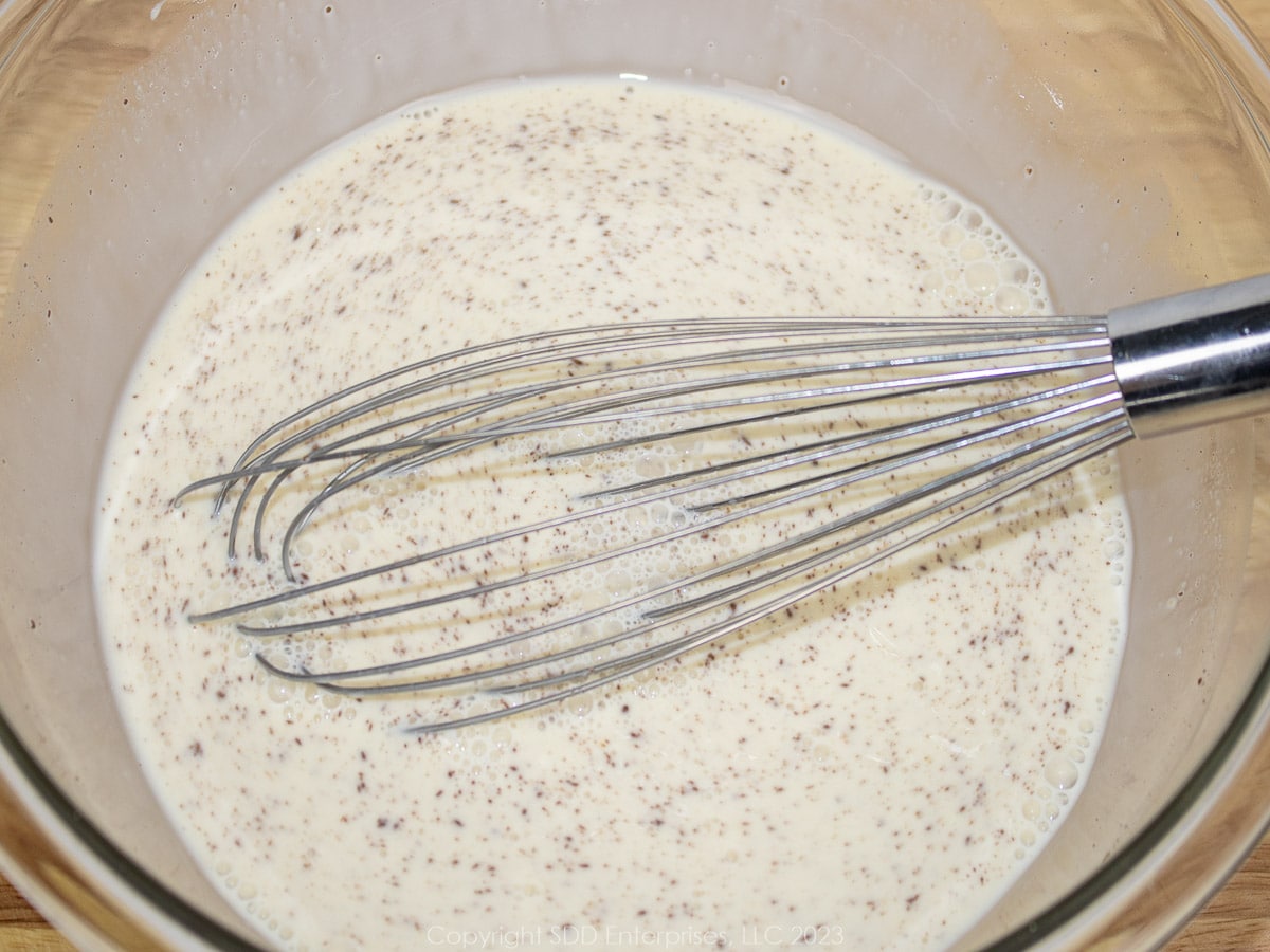 Custard ingredients for Pain Perdu whisked together in a glass bowl.