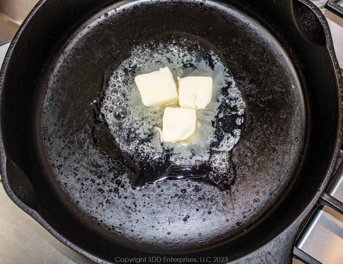 Butter melting in a hot cast iron skillet.