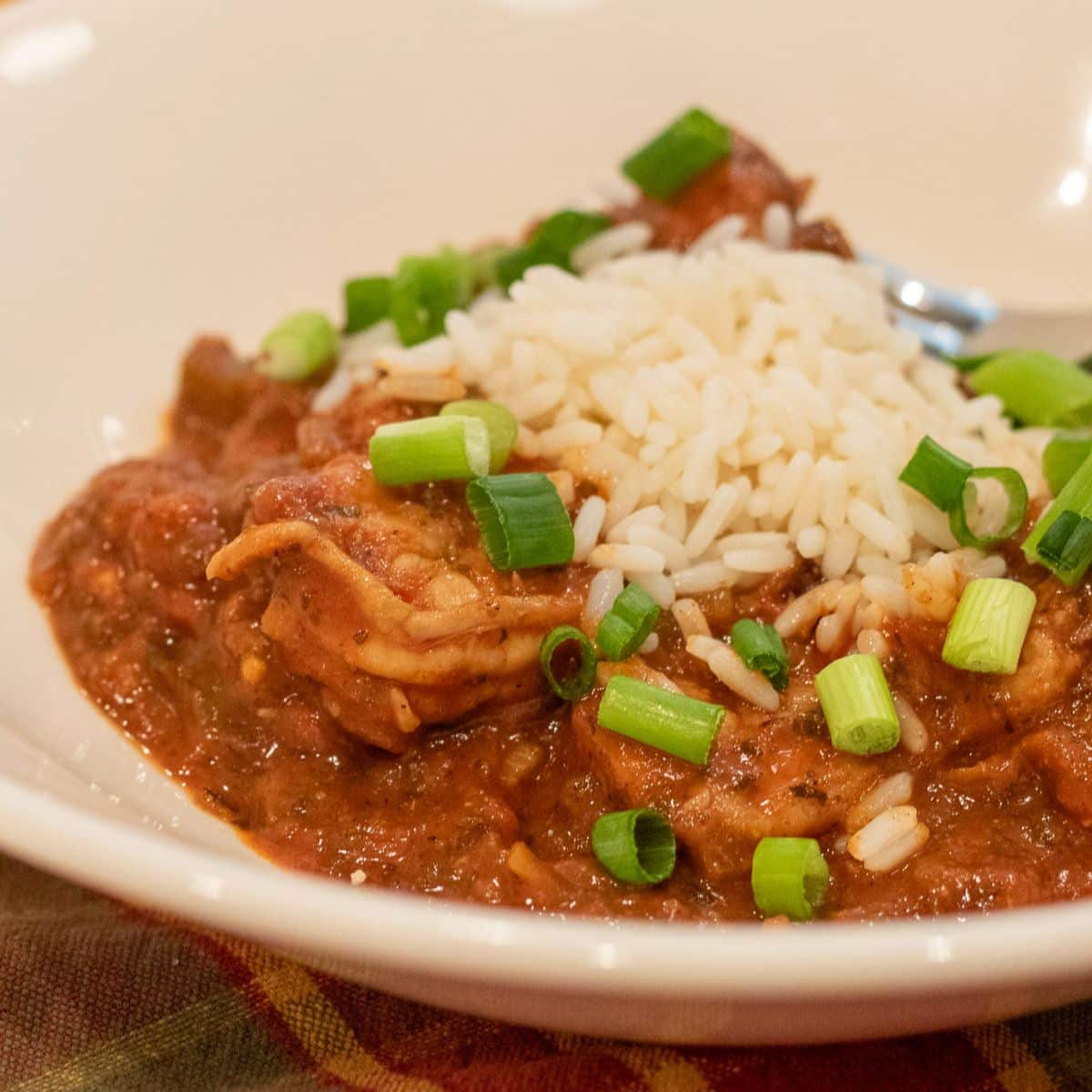 shrimp creole with rice and garnish in a white bowl