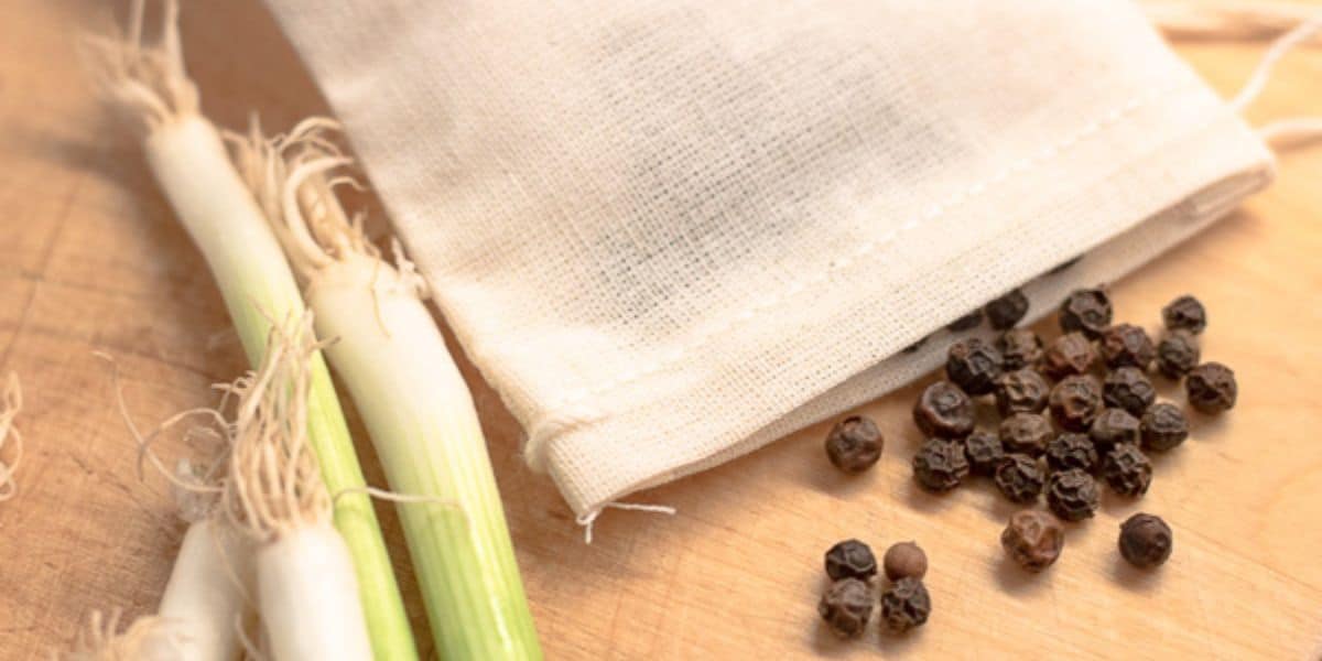 peppercorns spilling from a garni bag with green onions.