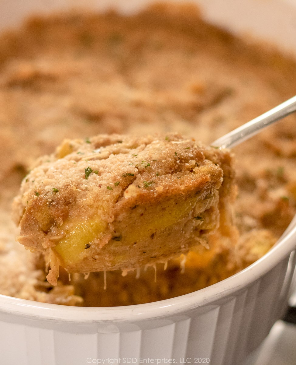 Yellow Squash Casserole with a serving spoon.