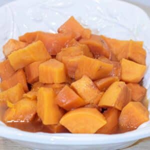 Candied Sweet Potatoes in a white serving dish.