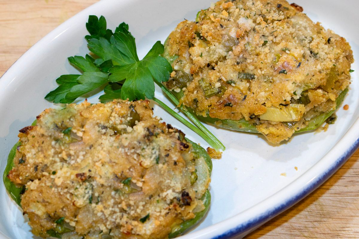 Two stuffed mirlitons in a blue and white serving dish with garnish.