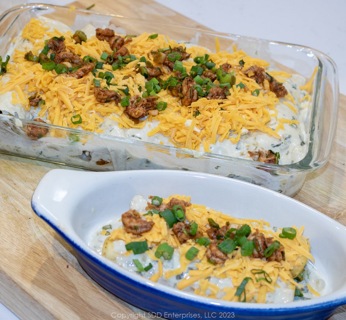 Crawfish Enchiladas with Creamy Enchiladas Sauce topped with cheese ready for the oven.