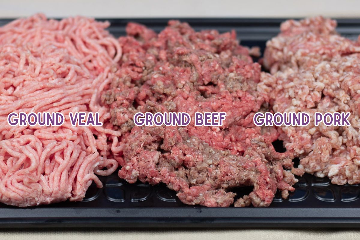 Ground beef, pork, and veal on a black prep tray.