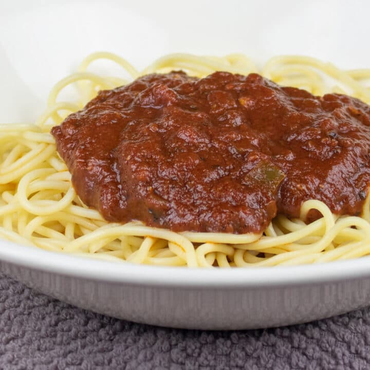 Tomato Sauce on top of a bowl of spaghetti noodles.