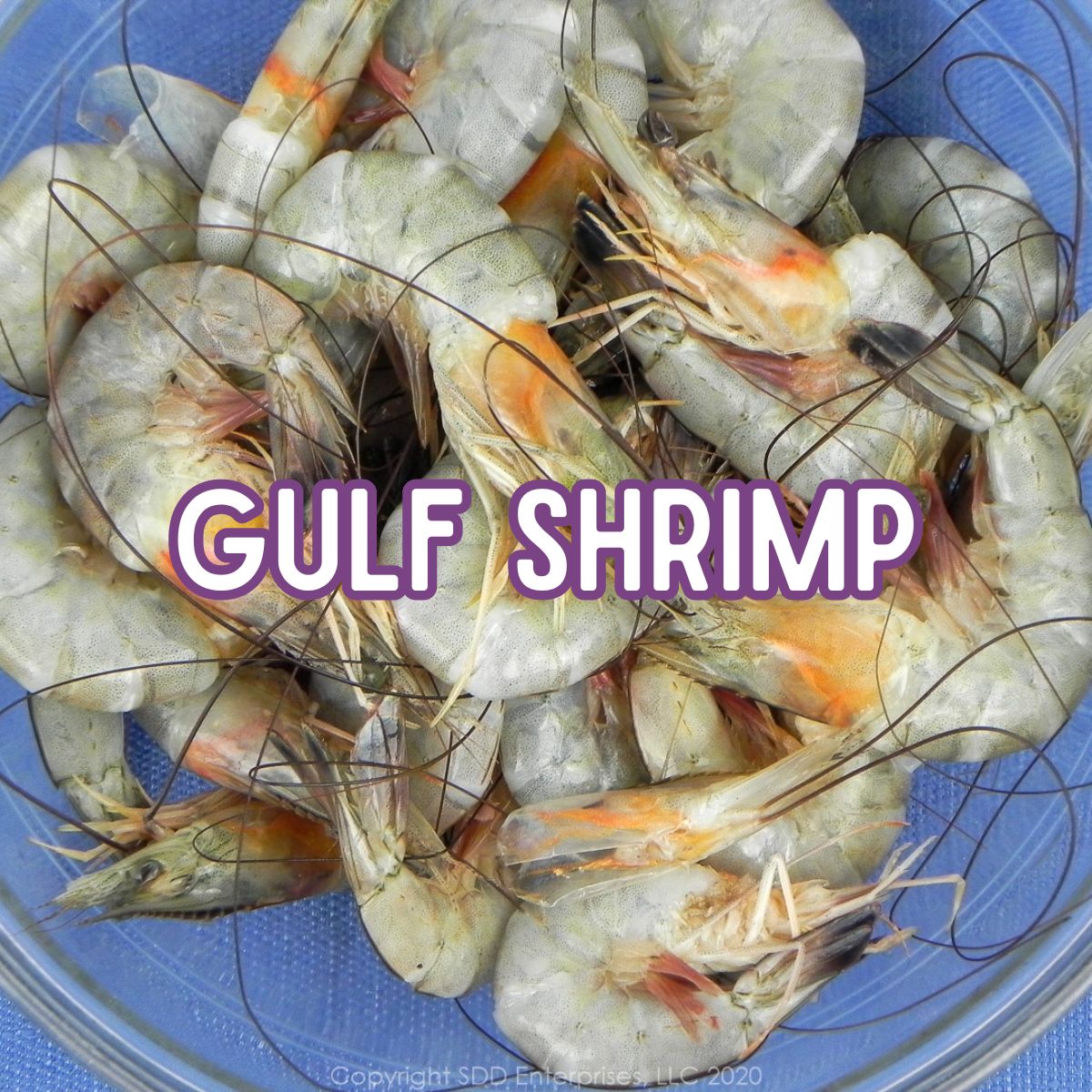 Fresh shell-on Gulf shrimp in a glass bowl.