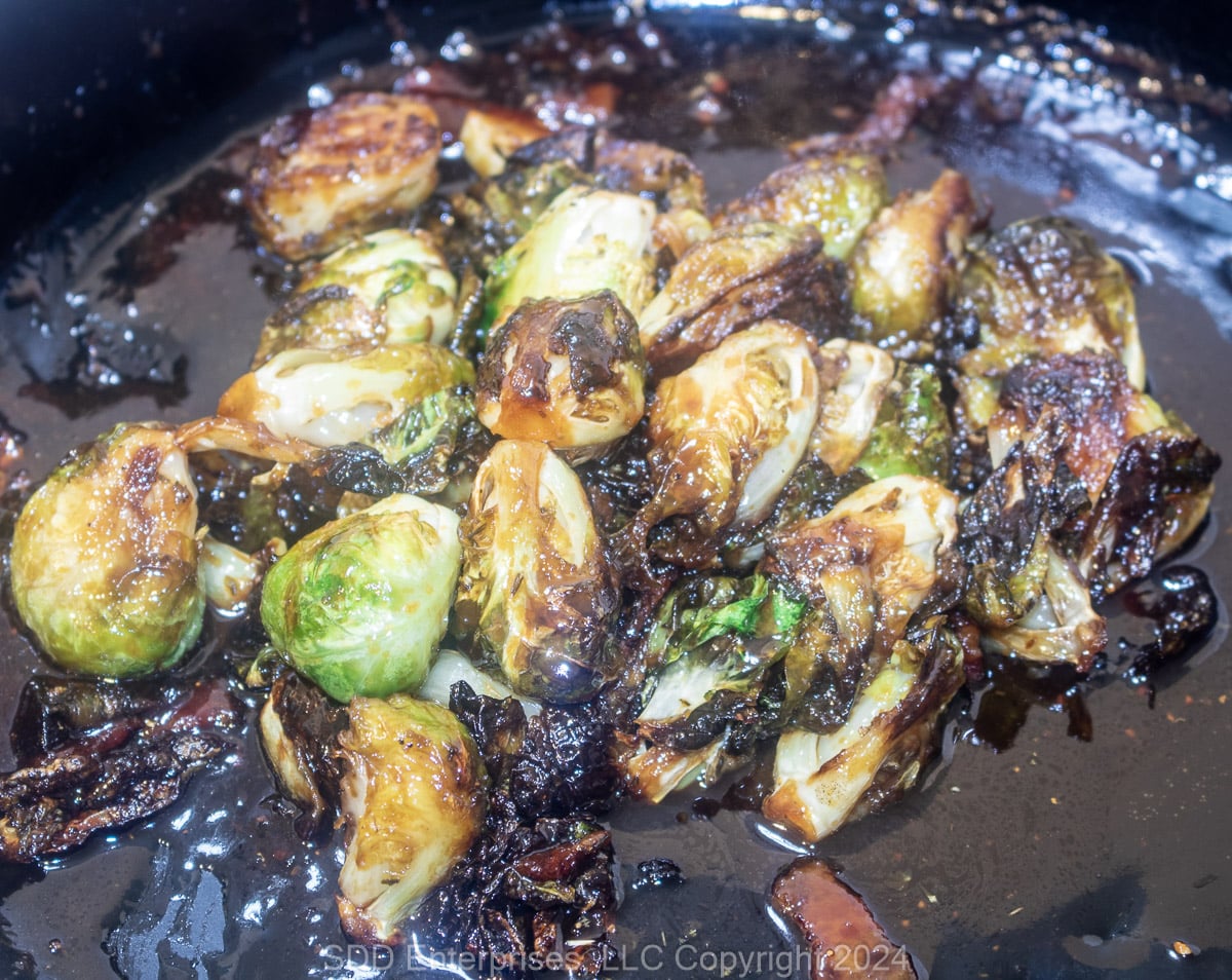 Roasted Brussels Sprouts with sauce in a roasting pan.