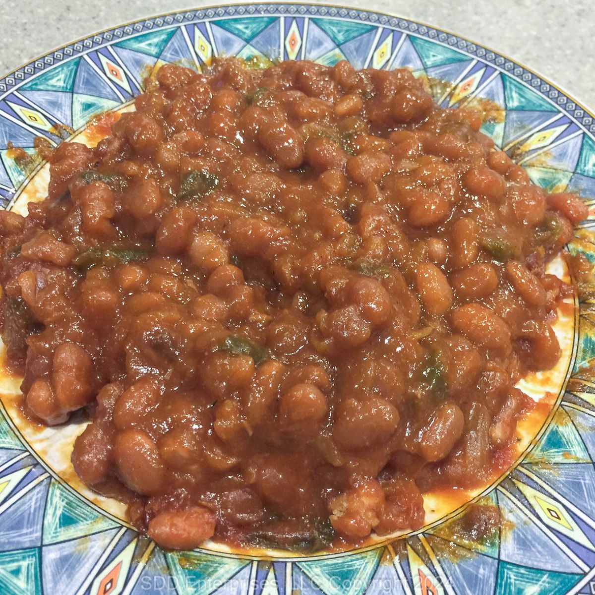 Baked Beans on a blue and green plate.